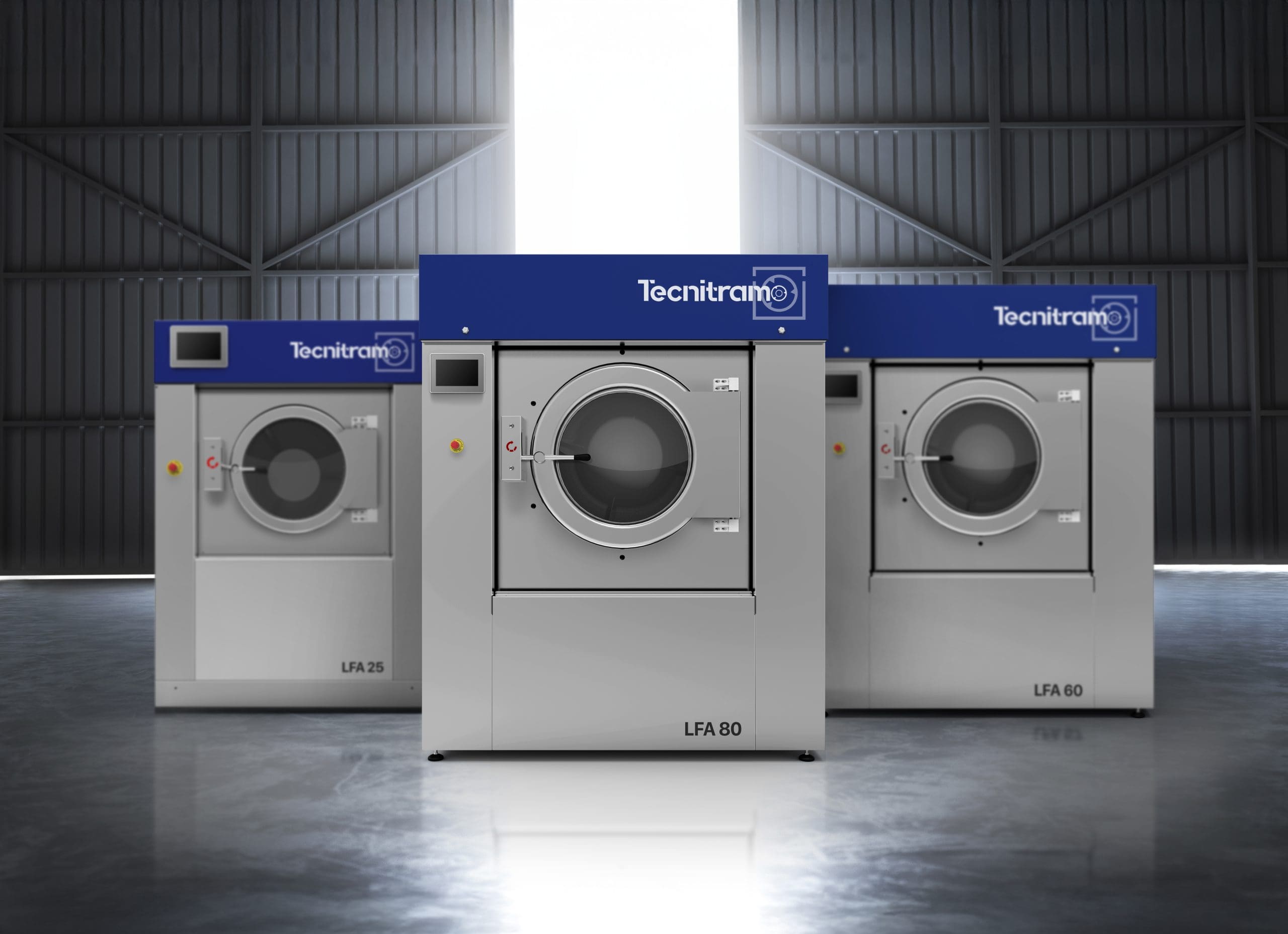 Three industrial washing machines labeled LFA 25, LFA 80, and LFA 60, with a blue "Tecnitramo" sign above each, are arranged in a spacious, well-lit warehouse with large windows in the background.